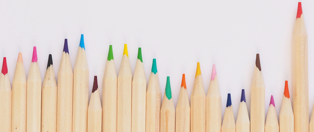 colored pencils lined up on a white surface