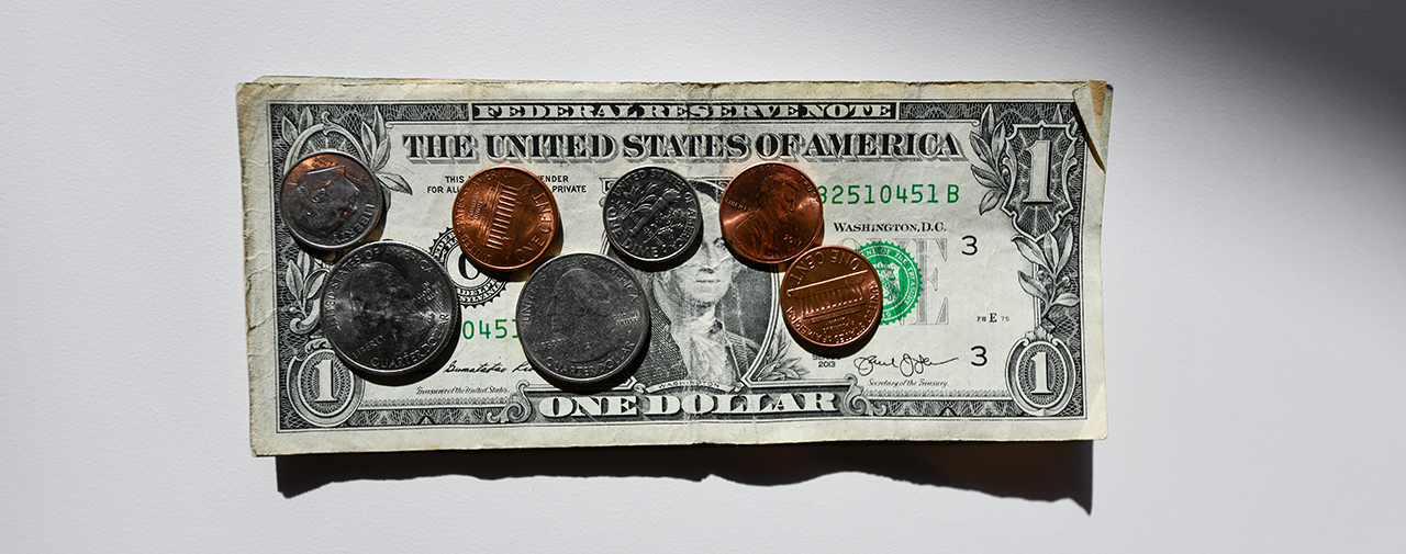 quarters pennies and dimes laying on a US dollar